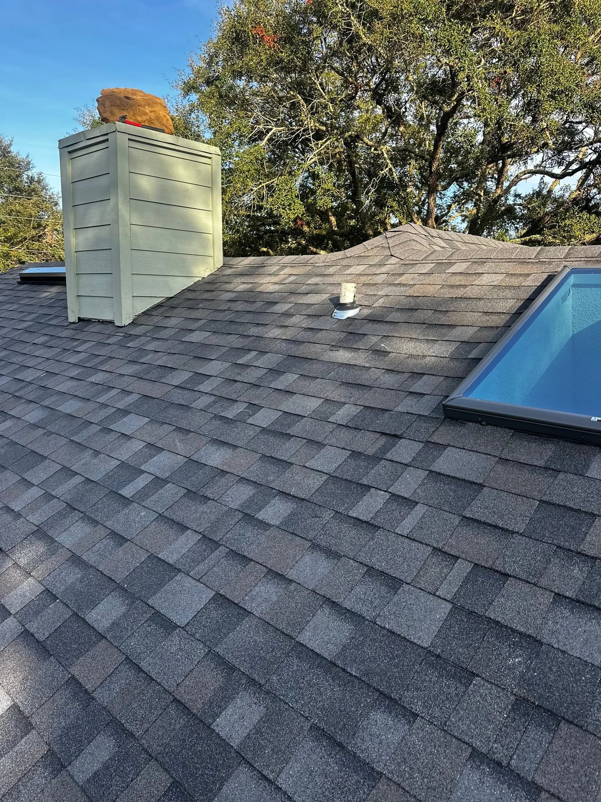 Finished architectural shingle roof with chimney and new skylights on a Fernandina Beach home
